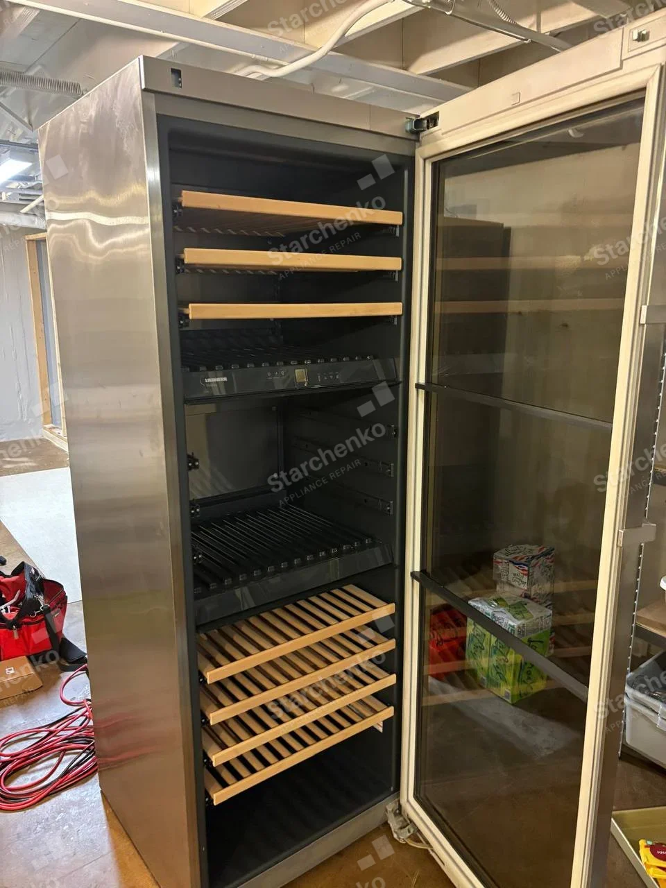 Liebherr repair: Tall glass-door wine refrigerator with wooden wine racks and inner control panel.