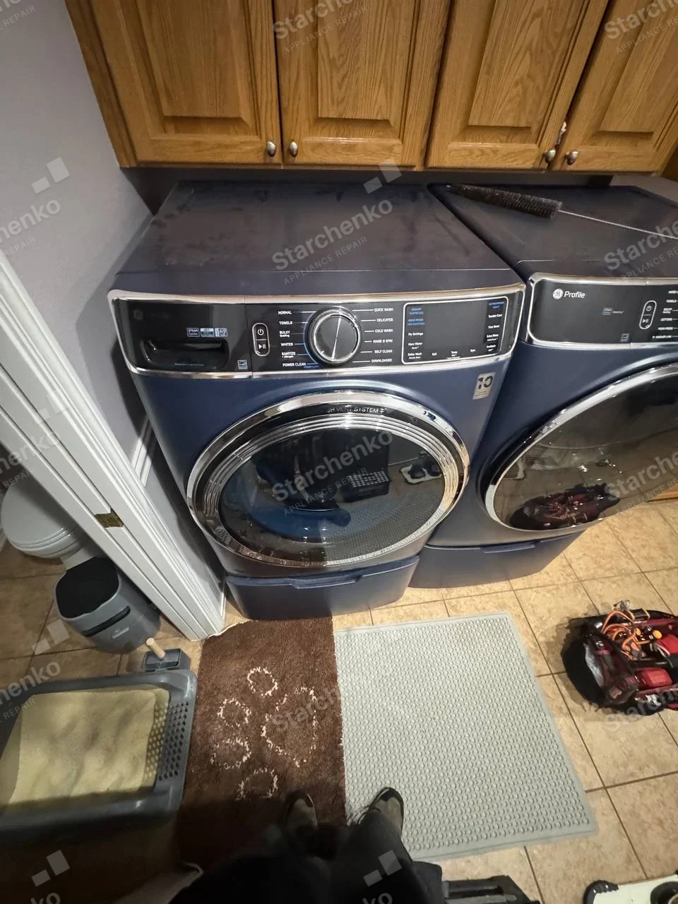 Electrolux repair: Left front-load washer with detergent drawer and cycle controls beside a dryer visibly marked Profile, dryer brand is not assigned to washer.