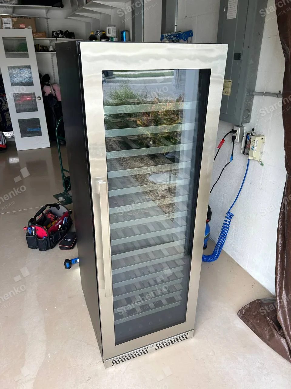 Perlick repair: Tall narrow glass-door temperature-controlled wine cabinet with horizontal bottle shelves and bottom vent.