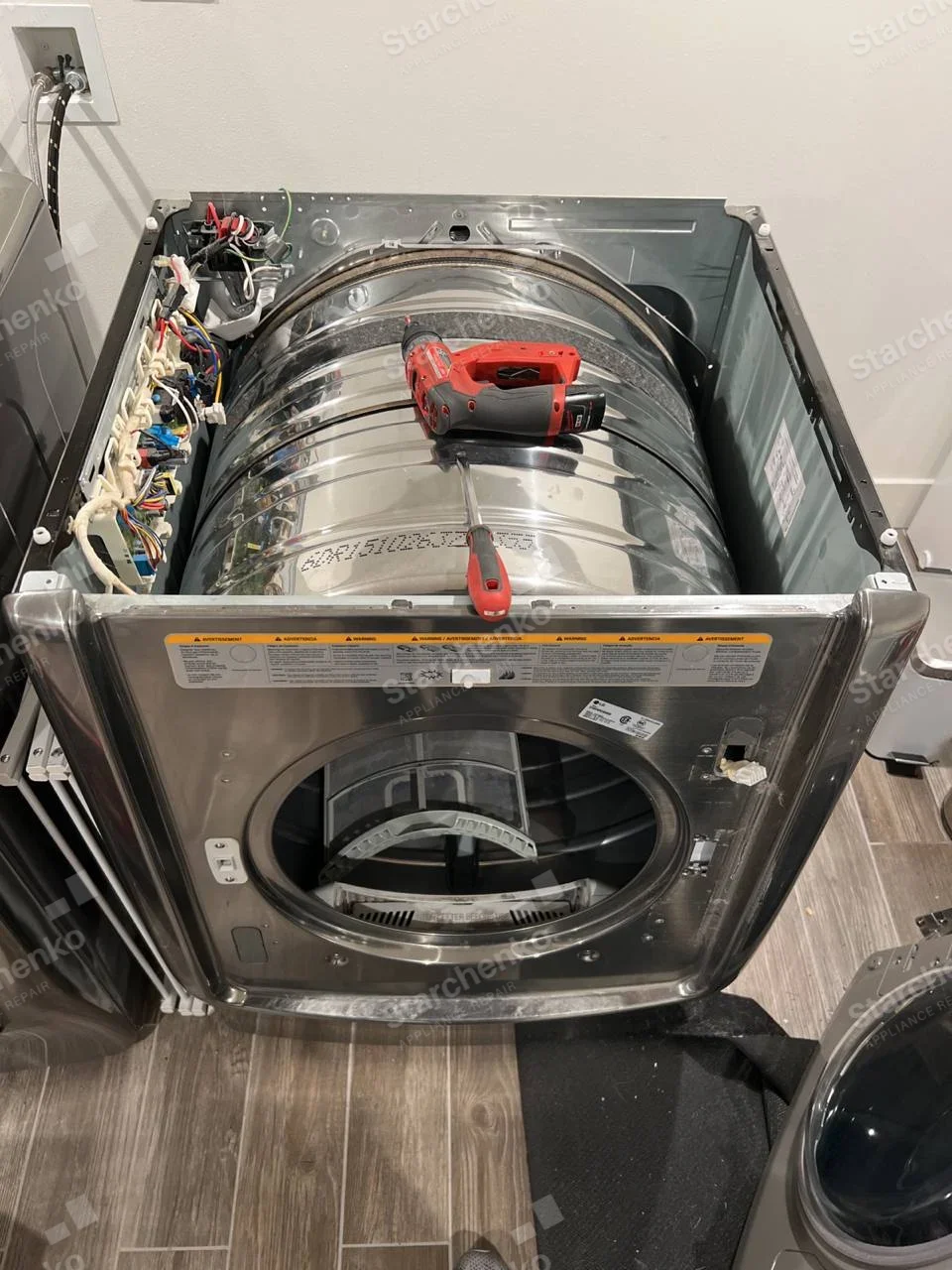 Kenmore repair: Dismantled front-load dryer with drum shell, controls and wiring exposed.