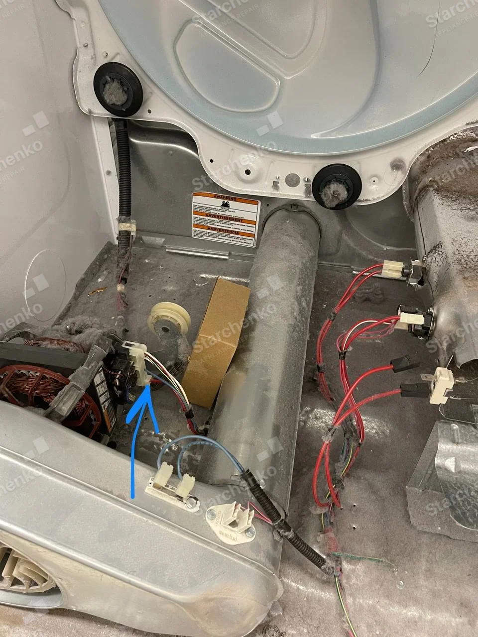 Frigidaire repair: Dryer lower cabinet exposed around motor, blower, heater housing and drum support rollers.