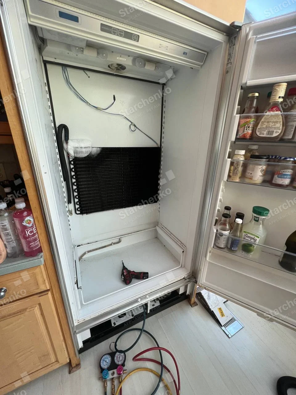 Viking repair: Open built-in refrigerator with interior liner removed, evaporator exposed and manifold gauges below.