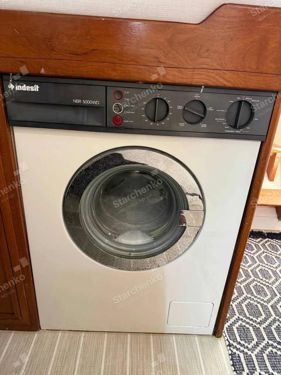 Built-in Indesit front-loading washer-dryer with wash and dry control settings on fascia.