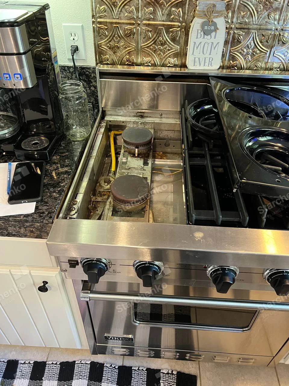 Viking gas range with left cooktop panels removed, exposing two burners.
