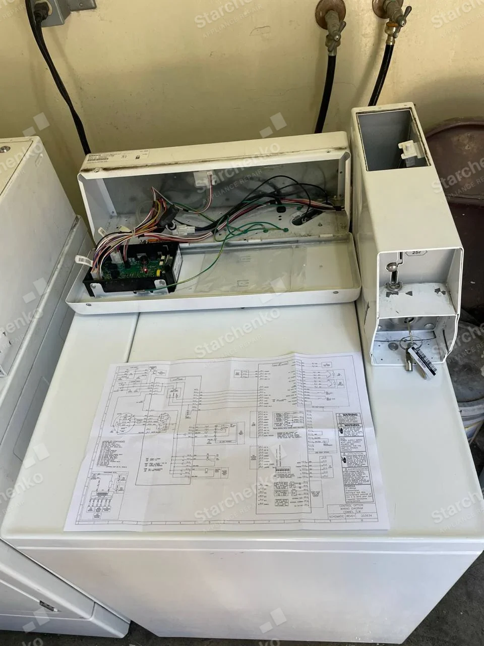 GE repair: Coin-operated top-load washer with control console and coin slide opened, circuit board and wiring exposed.