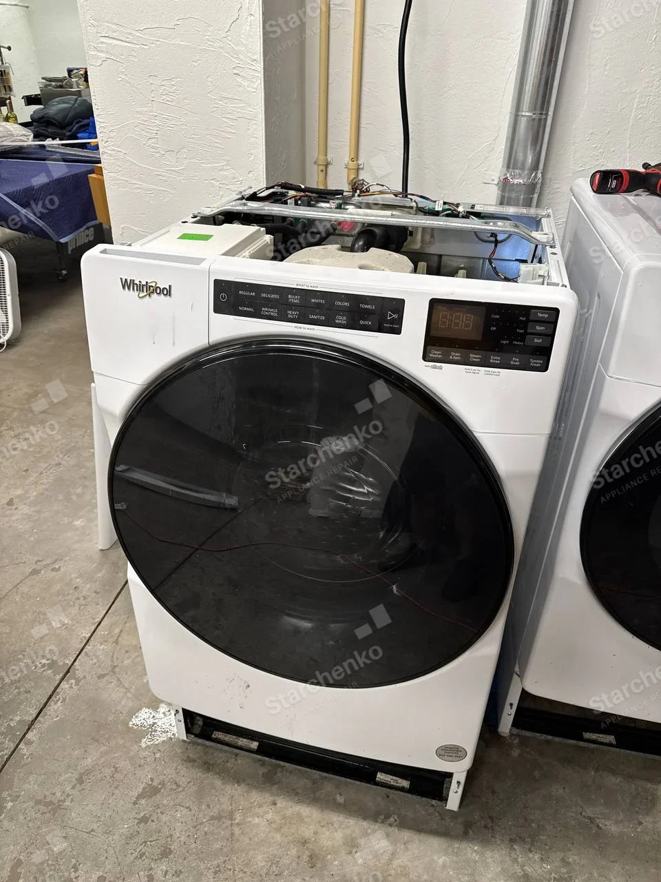 Whirlpool front-load washer with wash cycle, temperature and soil controls, top panel removed.