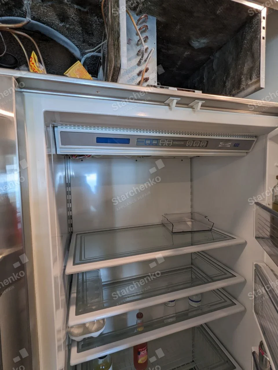 Viking repair: Open built-in refrigerator interior below exposed top machinery compartment.