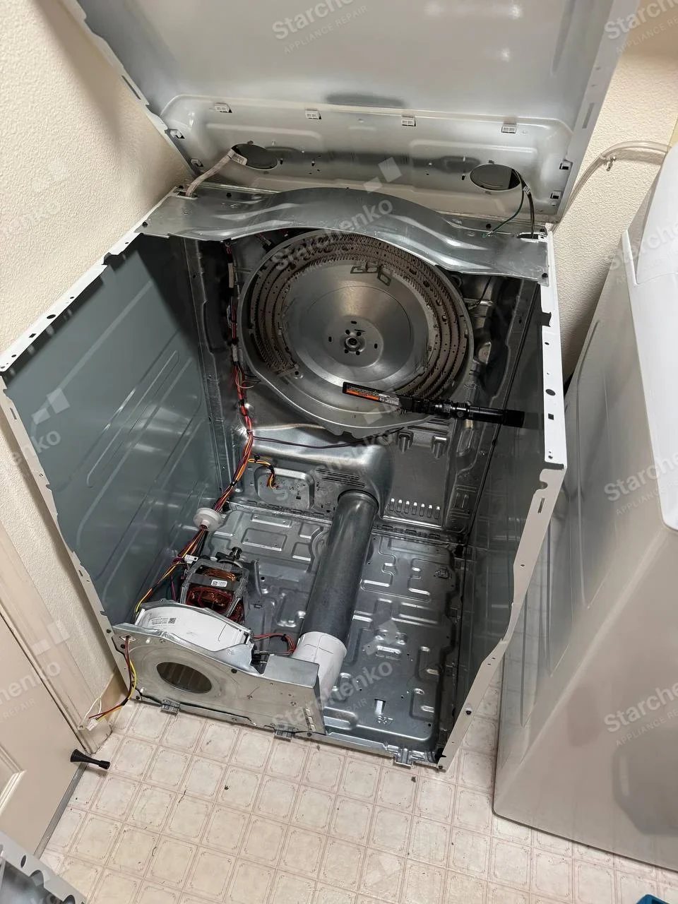 Samsung repair: Dryer cabinet opened with drum removed, heater, motor and blower exposed.