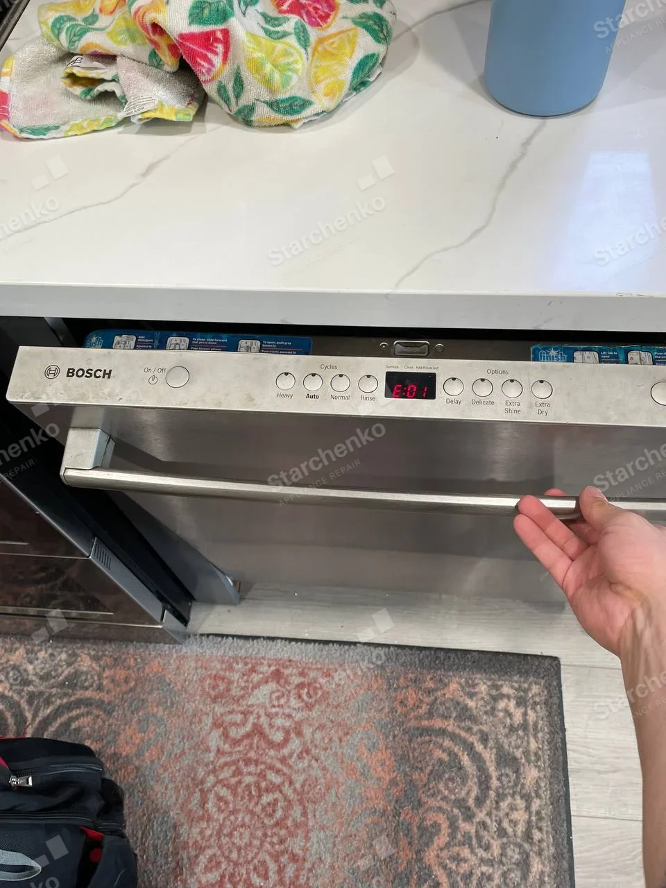 Bosch dishwasher front control panel showing red E:01 error code.