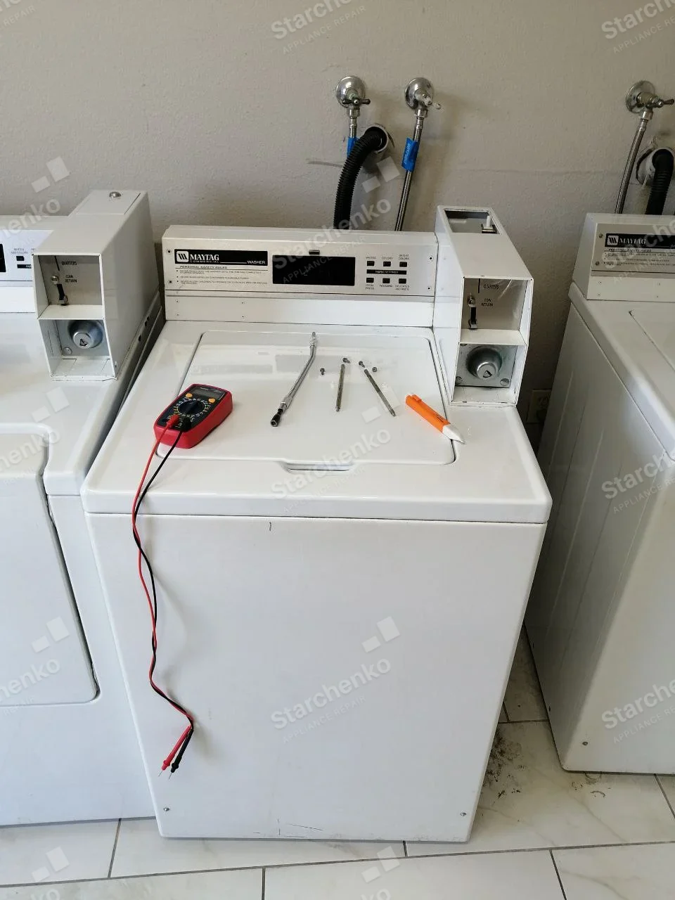 Maytag commercial top-load washer with coin mechanism and meter resting on closed lid.