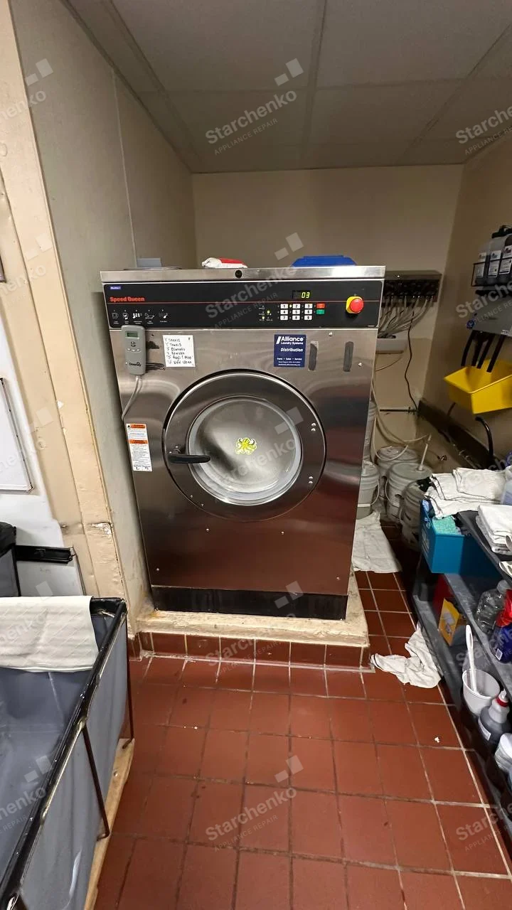 Speed Queen red lettering at upper-left of large stainless industrial washer control fascia, Alliance Laundry Systems distribution sticker is not brand.
