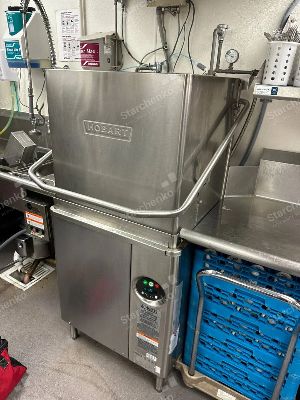 Commercial hood-type dishwasher with Hobart raised lettering on stainless hood and front control panel.