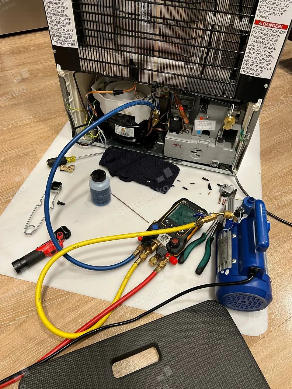 KitchenAid repair: Open rear of refrigerator with condenser grille, compressor and service gauge hoses.
