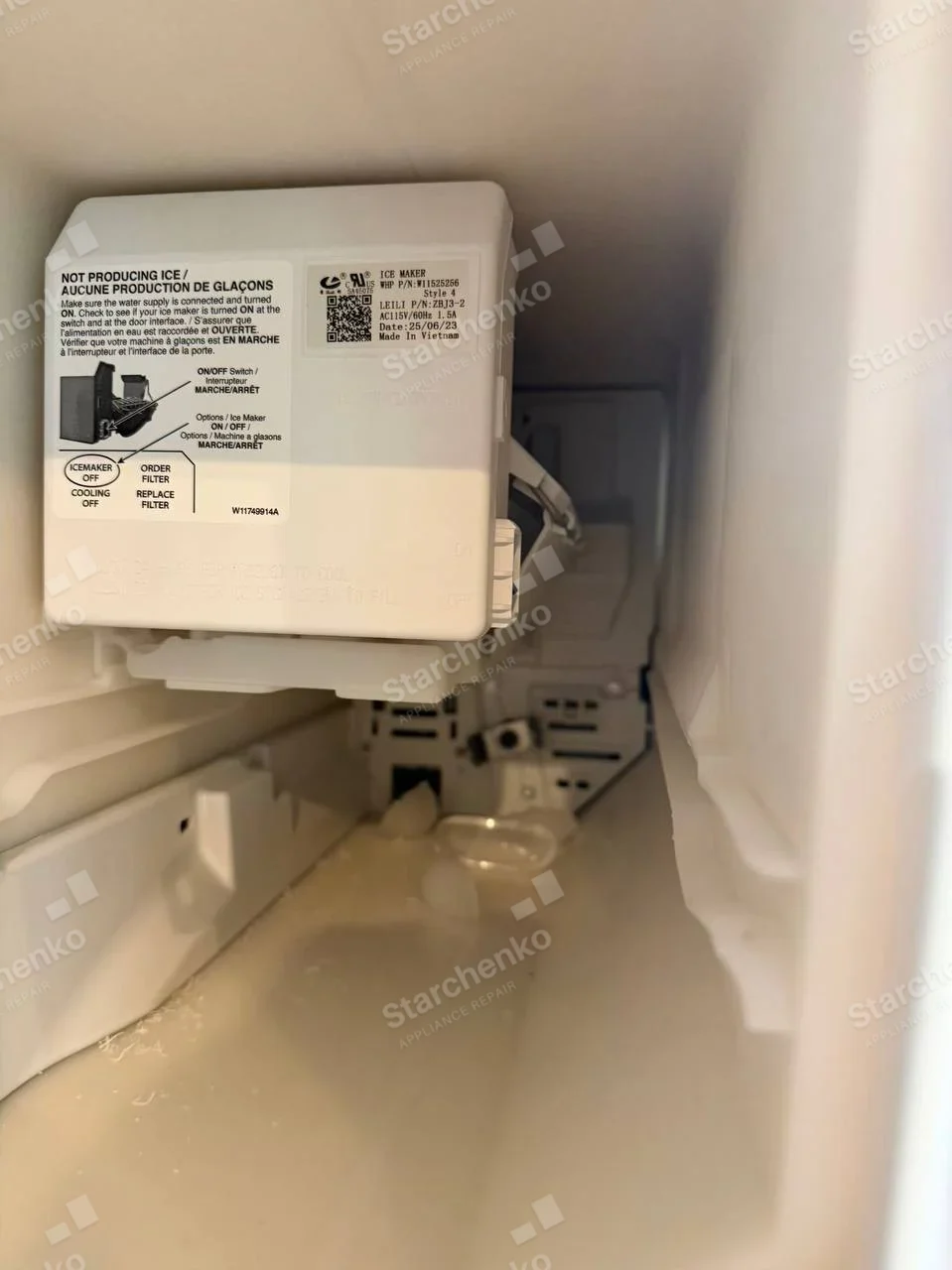 Kenmore repair: Close-up of ice-maker assembly installed inside a freezer compartment, label identifies only ice-maker component, not whole appliance.