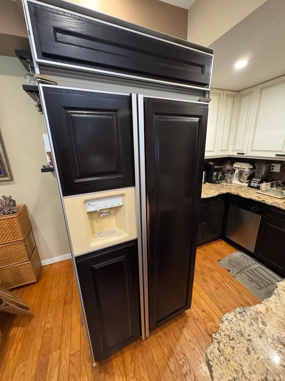 Large side-by-side refrigerator with a water dispenser pulled forward in a kitchen