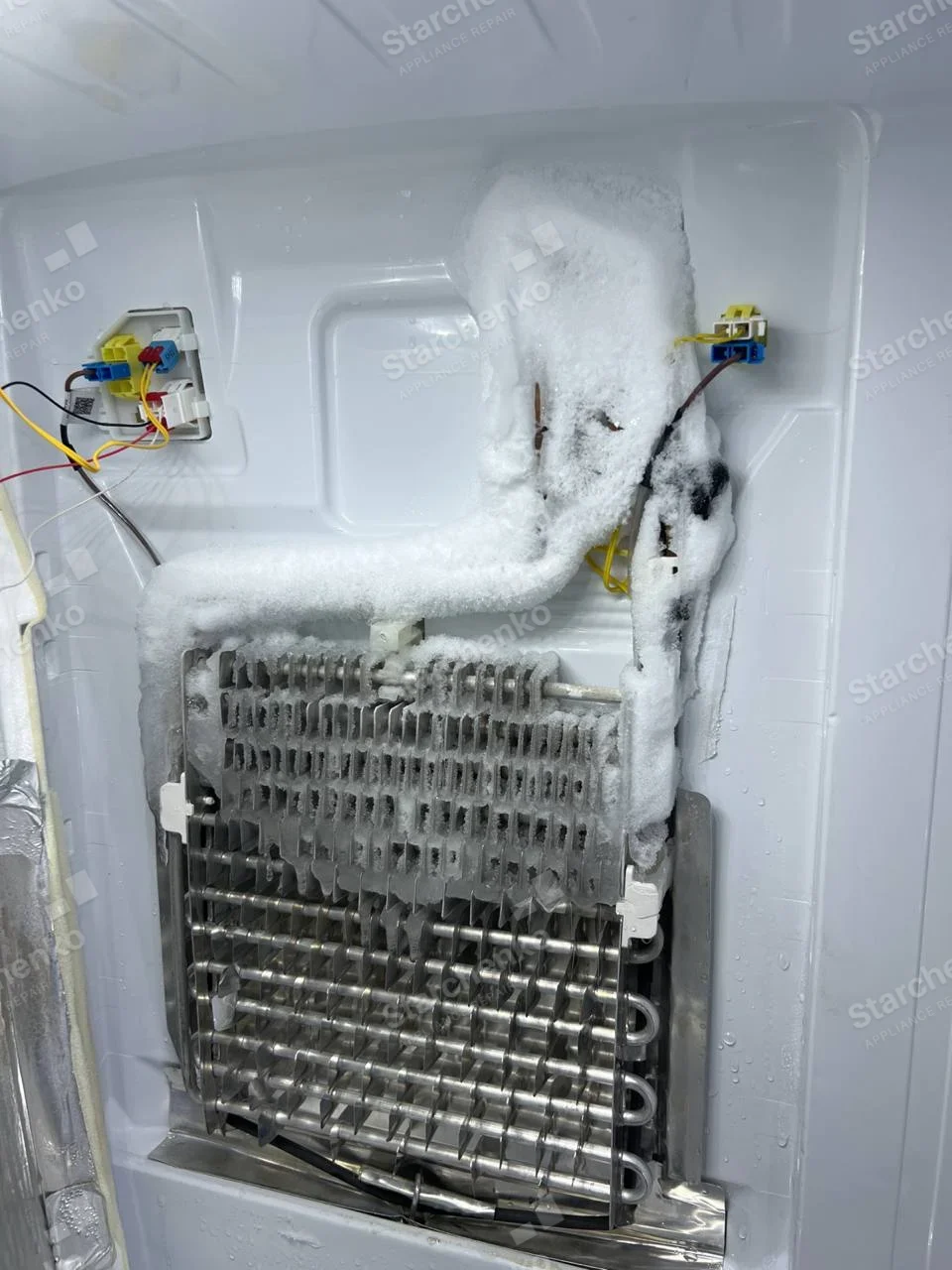 Kenmore repair: Exposed freezer evaporator coil with heavy frost on upper tubing and top fins.