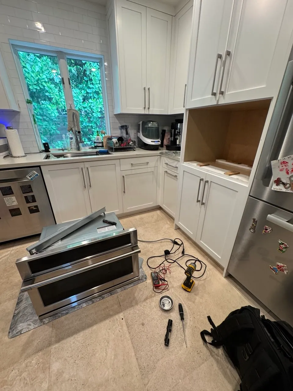 Built-in wall oven pulled out of the cabinet in a kitchen