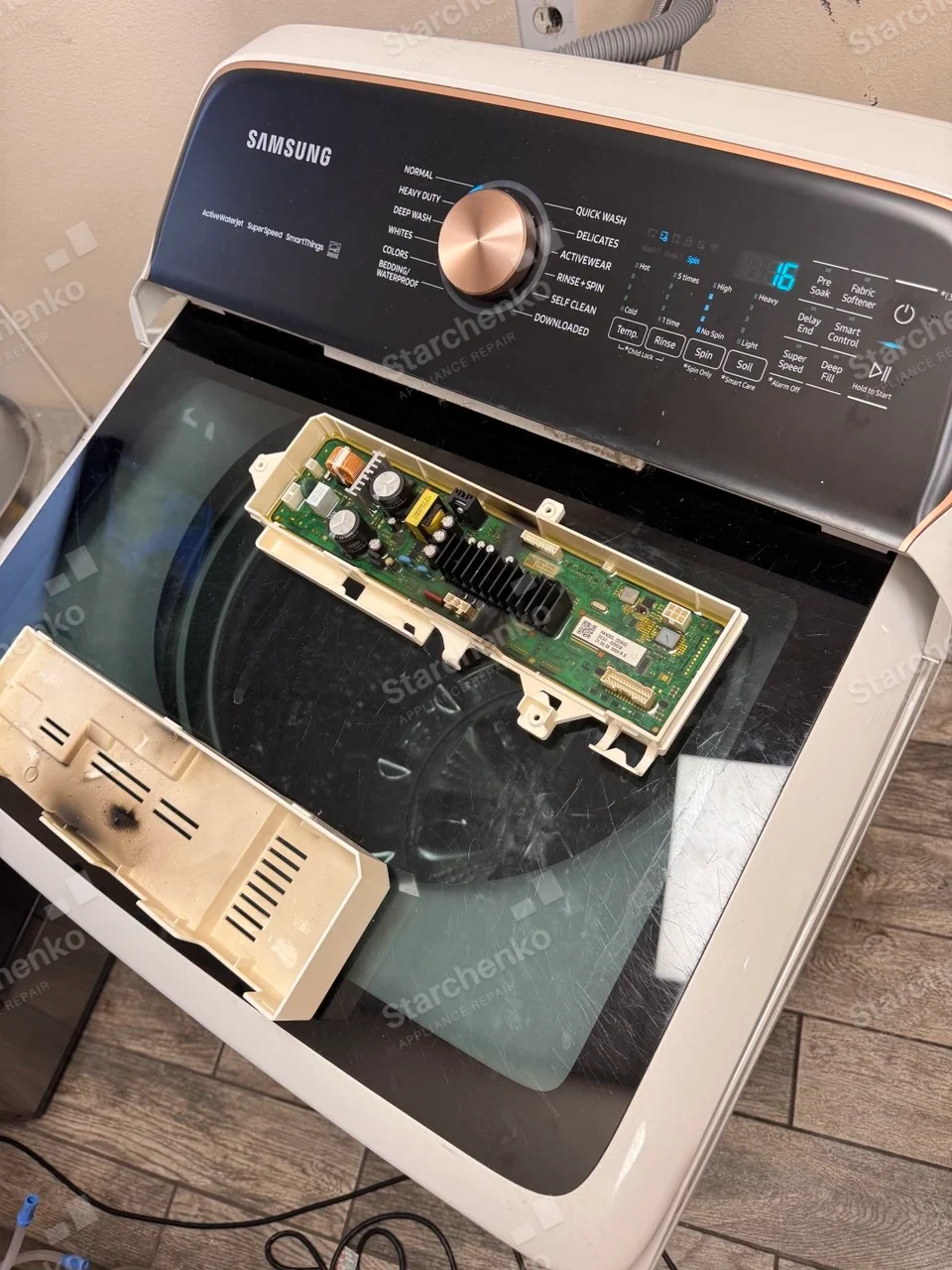 SAMSUNG word on main top-load washer control console, detached electronic board laid on lid.