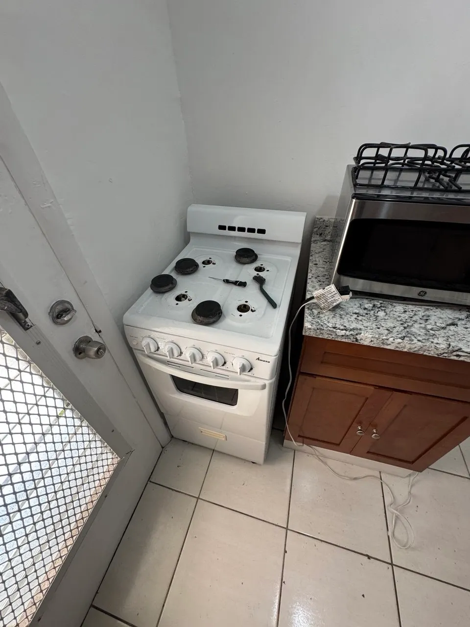 White gas range in a kitchen with a microwave above the counter