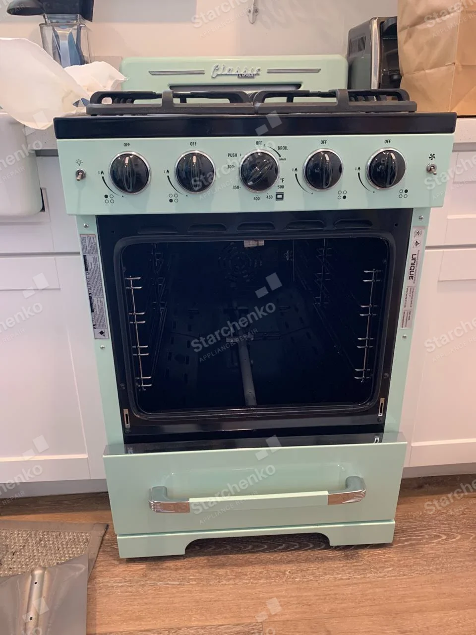 Mint-green Unique gas range with oven door removed and cavity exposed.