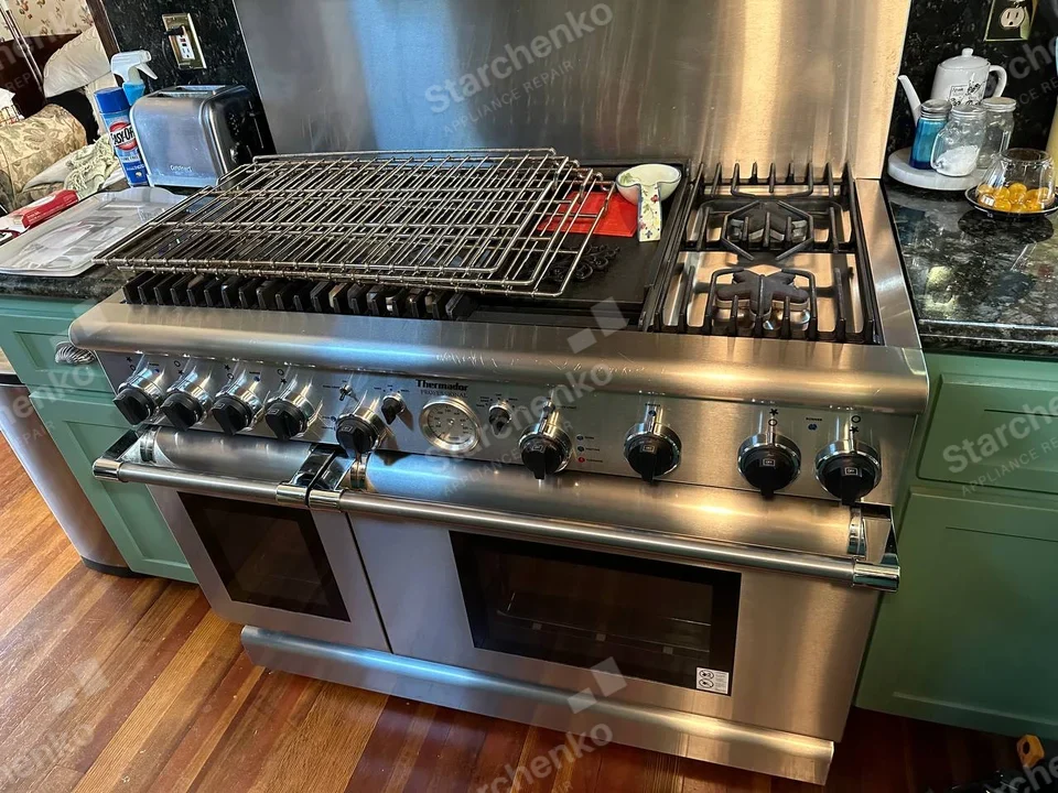 Wide Thermador Professional dual-oven gas range with lifted grill rack and burner grates.