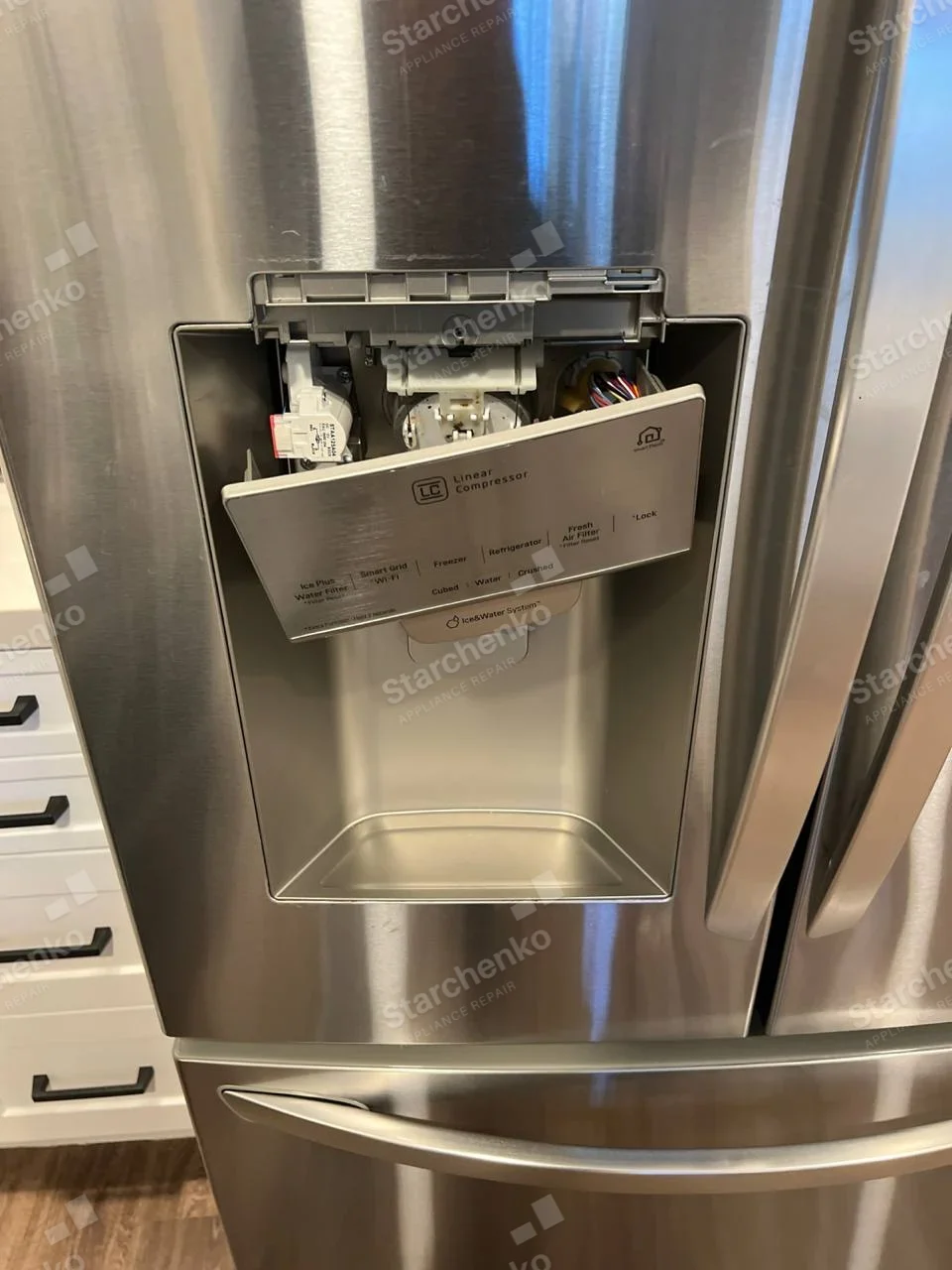Kenmore repair: Stainless French-door refrigerator with lower freezer drawer, ice/water dispenser control panel hanging open, Linear Compressor text is component/technology label, not an appliance brand.