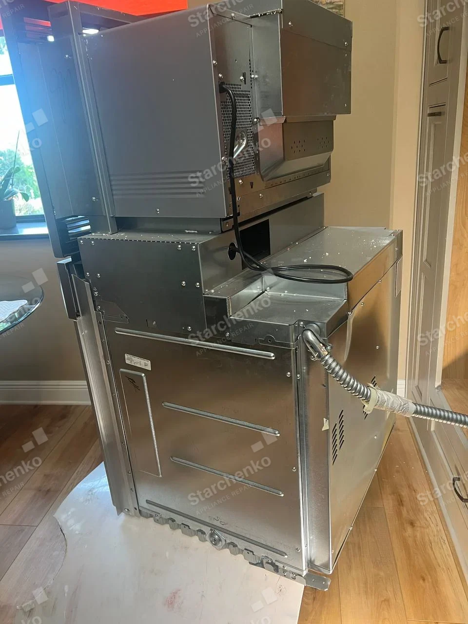 Rear side of removed Bosch wall oven and microwave combination, with electrical conduits and cooling ducts visible.
