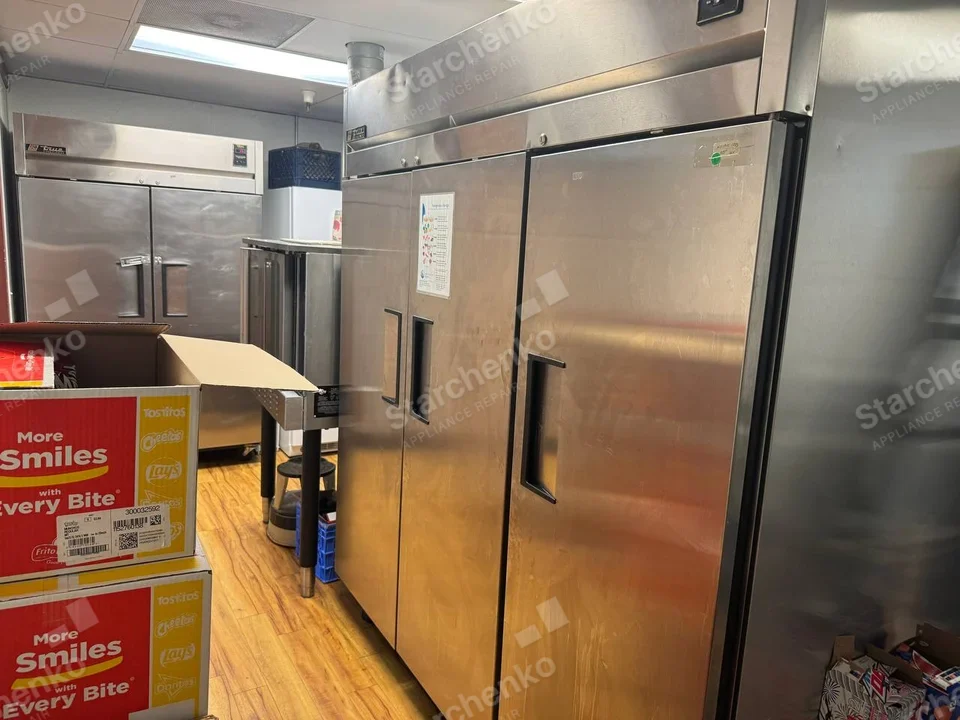 Delfield repair: Large three-door commercial upright refrigerator in foreground.