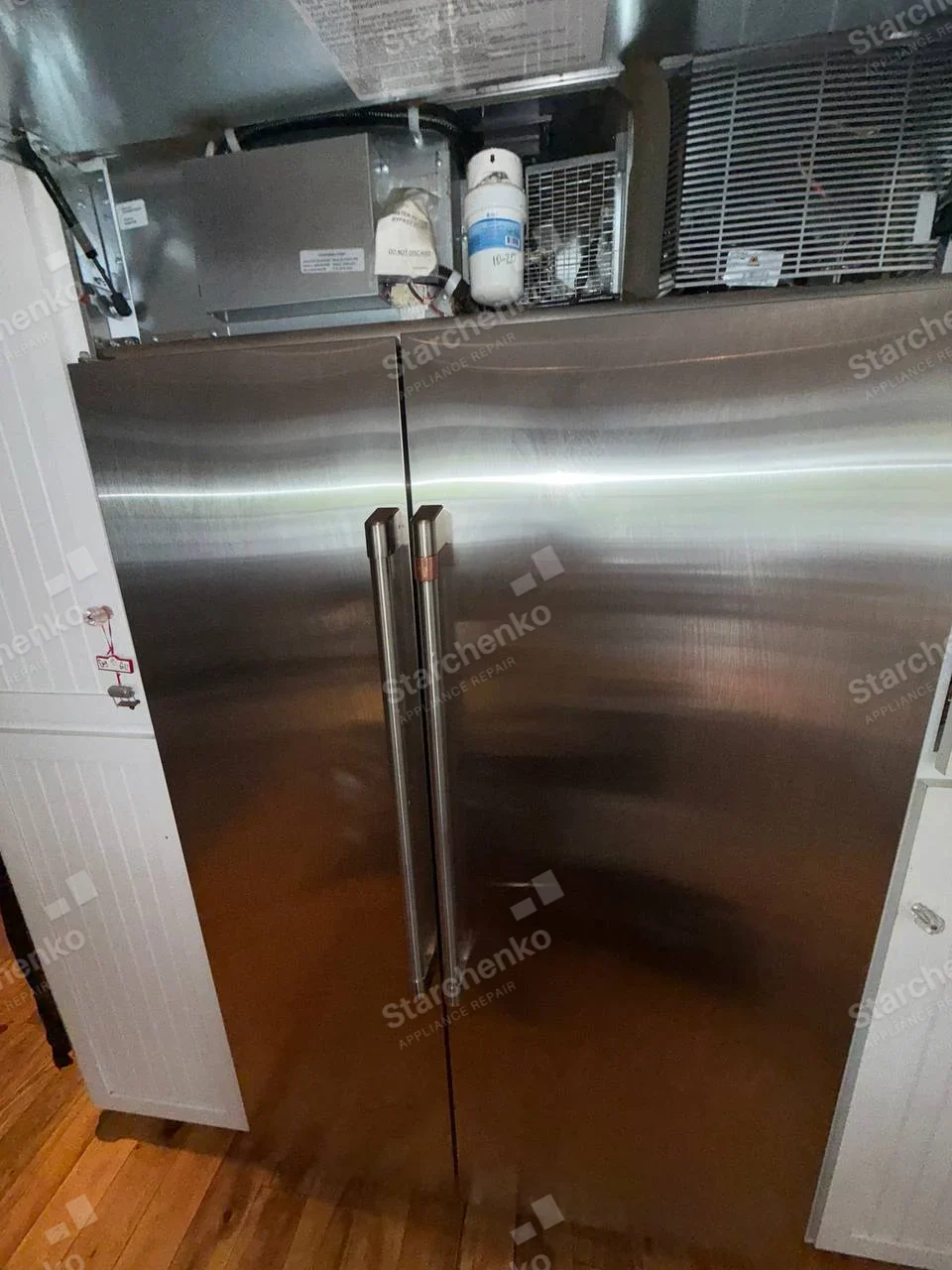 GE Profile repair: Built-in side-by-side refrigerator with upper cooling system exposed.