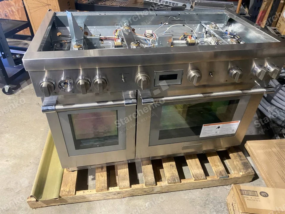 Amana repair: Wide stainless gas range with two oven doors and removed cooktop exposing burners and wiring on a pallet.