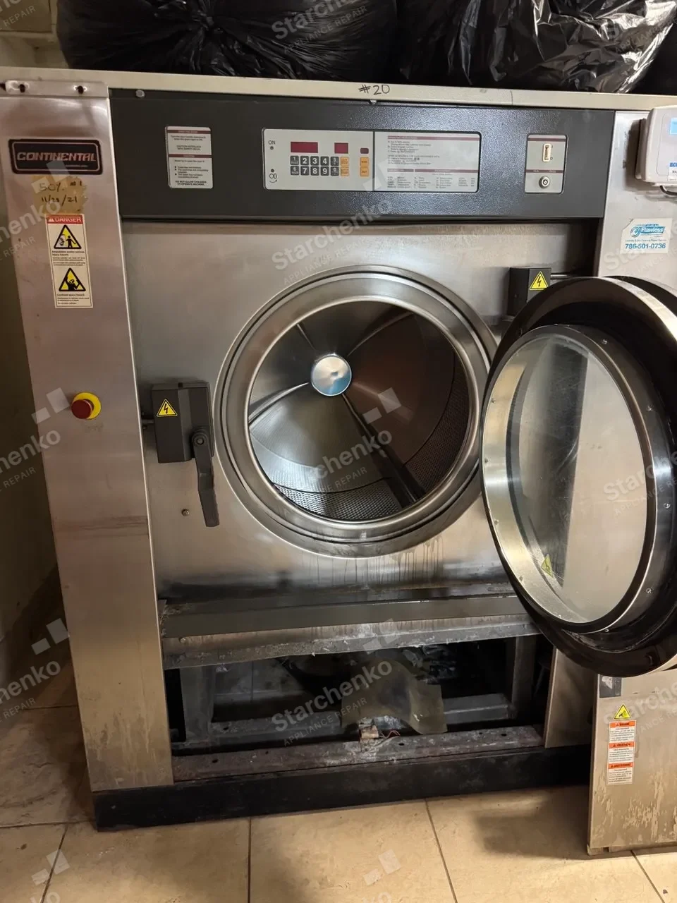 Commercial washer-extractor by Continental with its perforated drum and lower service area exposed