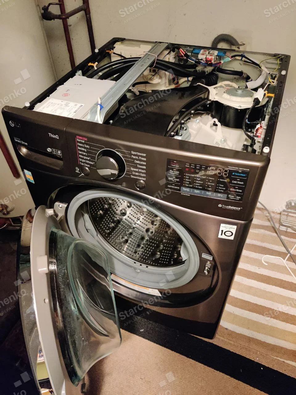 LG logo on front upper-left of washer, top cover removed showing tub and drive motor.