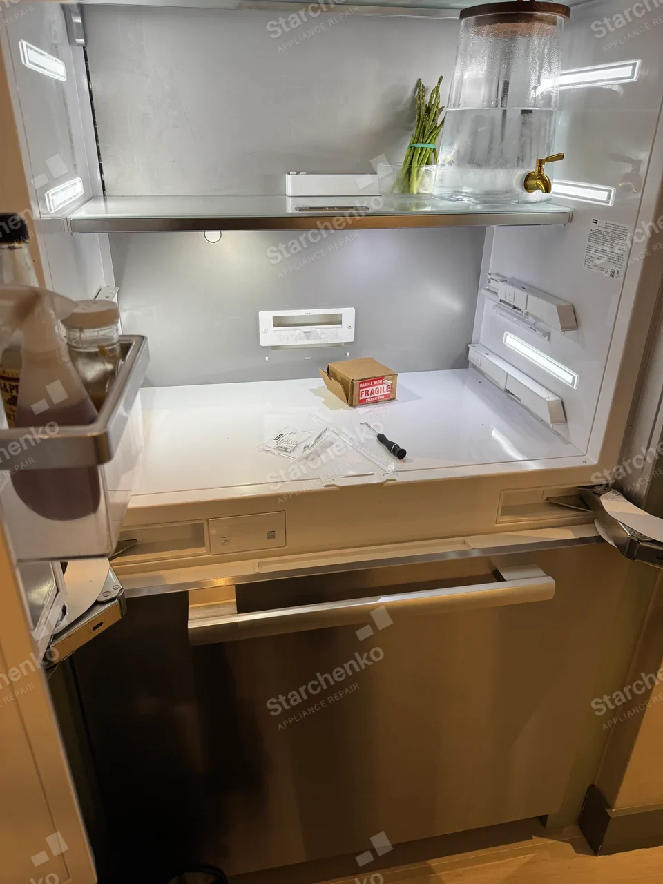 Maytag repair: Refrigerator interior with open shelf and service tools.