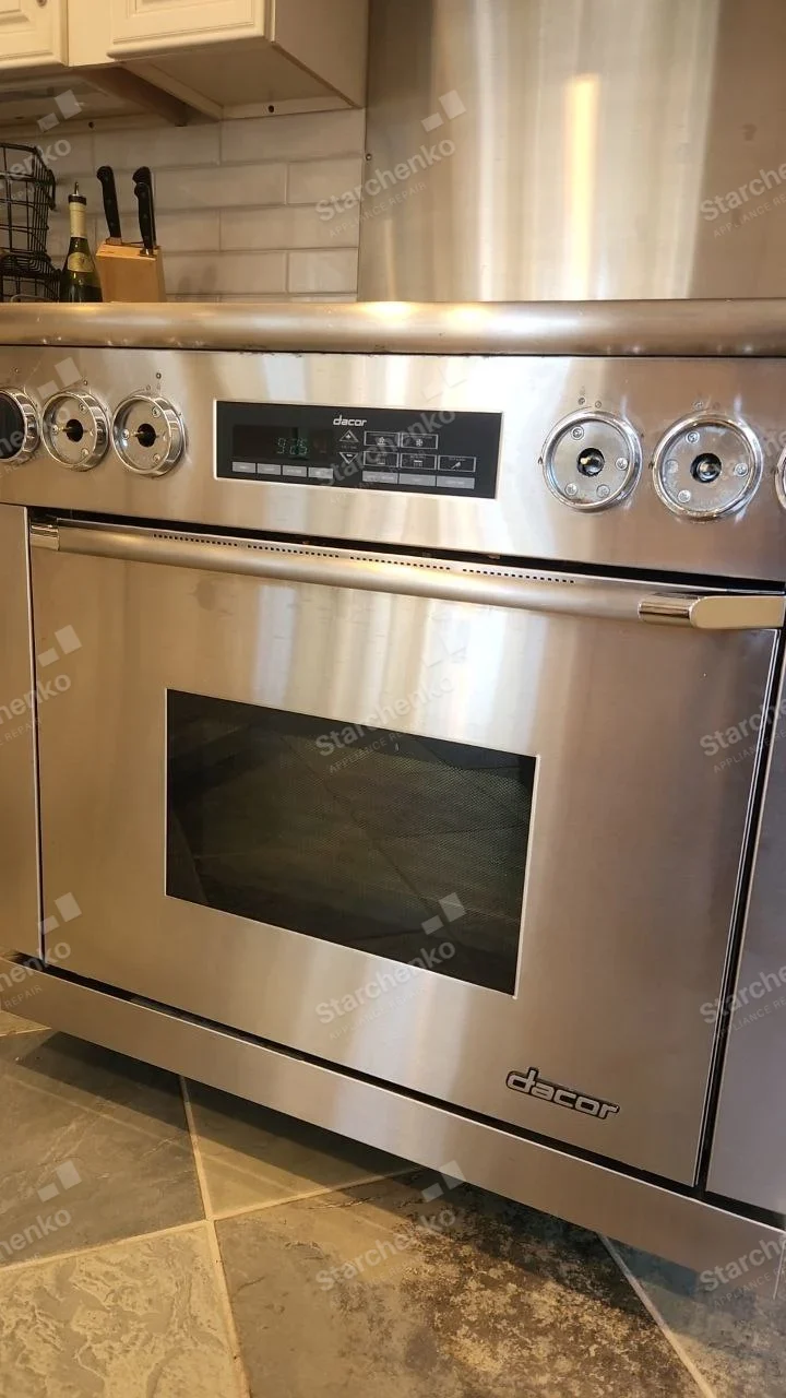 Stainless Dacor range with multiple control knobs removed from front panel.