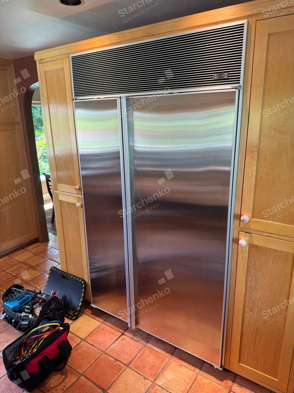 SUB-ZERO badge on upper-right grille of the large side-by-side refrigerator.
