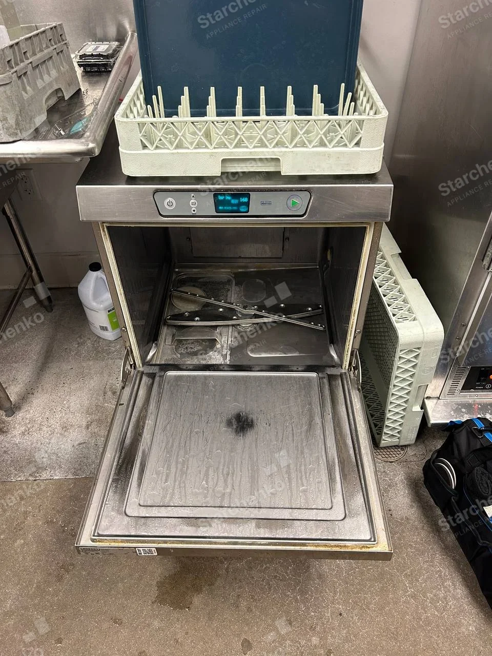 Moyer Diebel repair: Open undercounter commercial dishwasher with spray arms removed and rack resting on top.