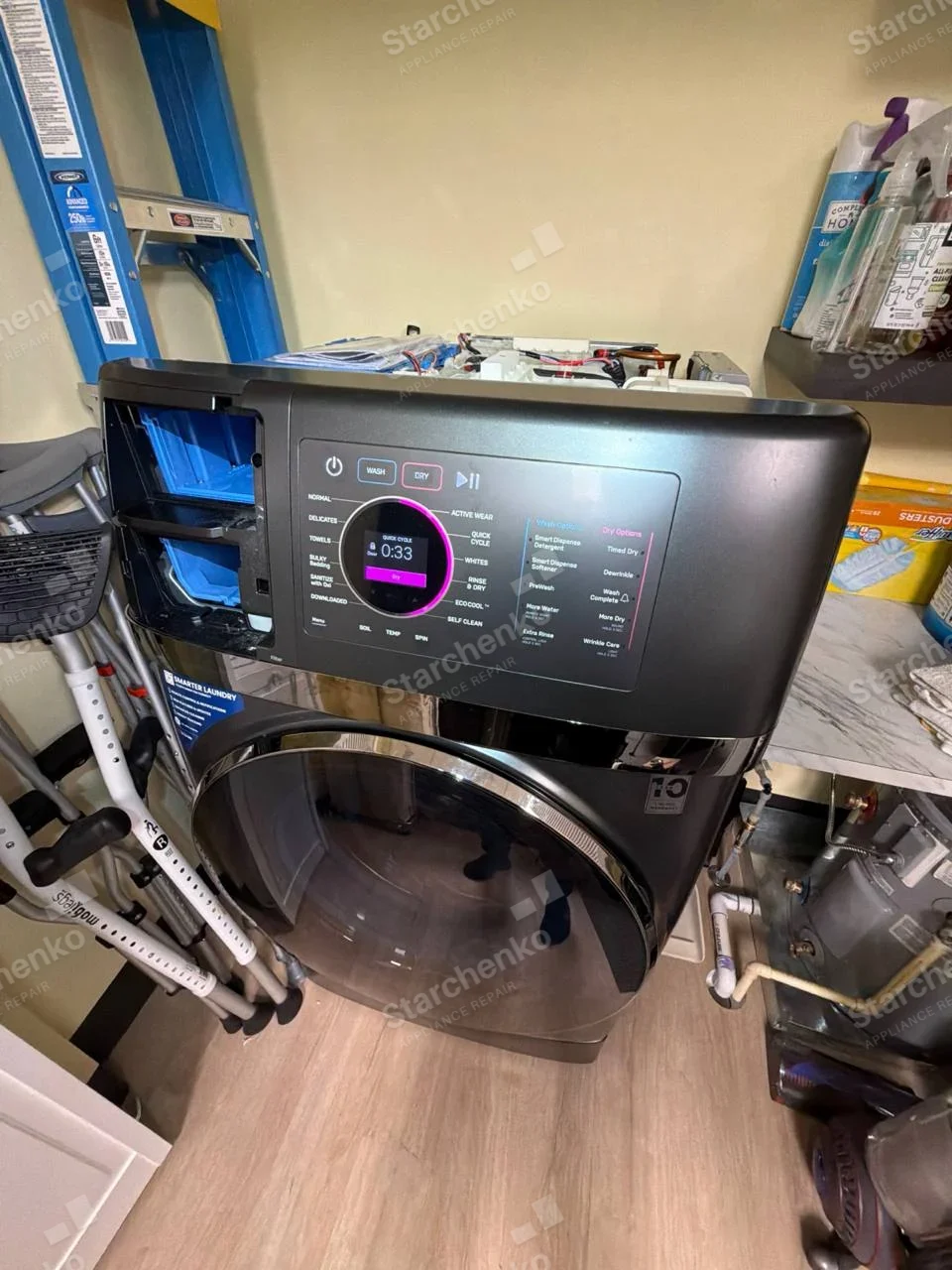 All-in-one washer-dryer with the top cover off and the detergent dispenser drawer pulled out