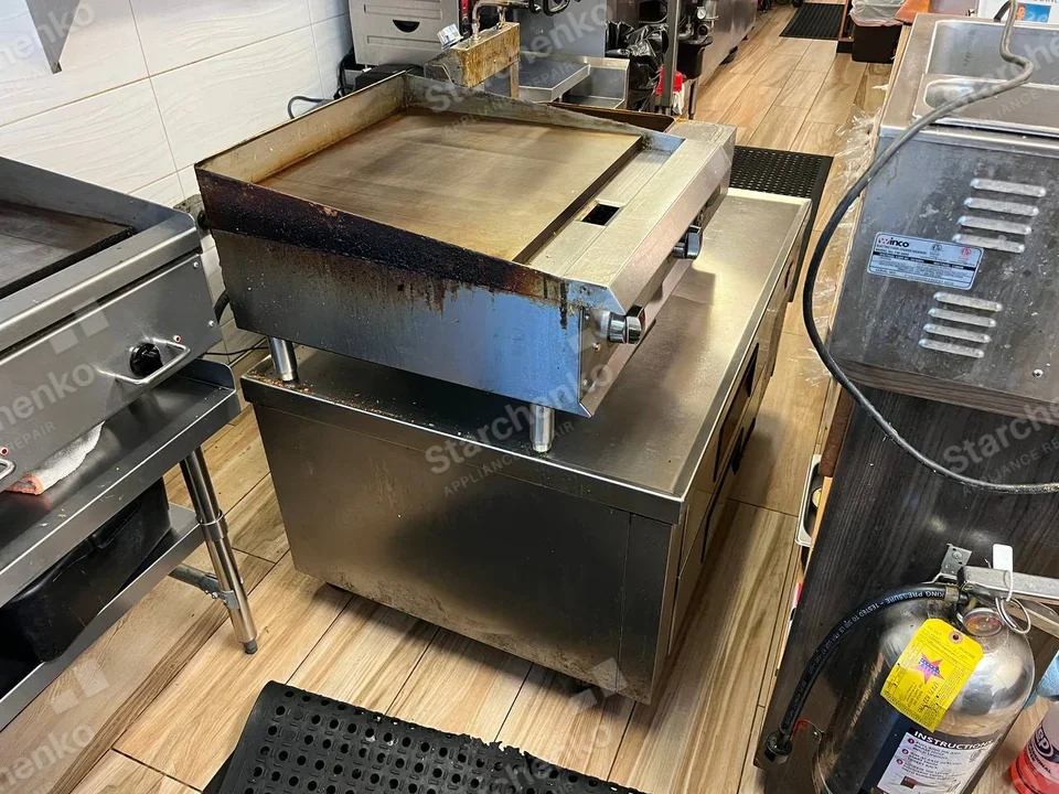 Countertop commercial griddle on a stainless equipment stand in a restaurant kitchen