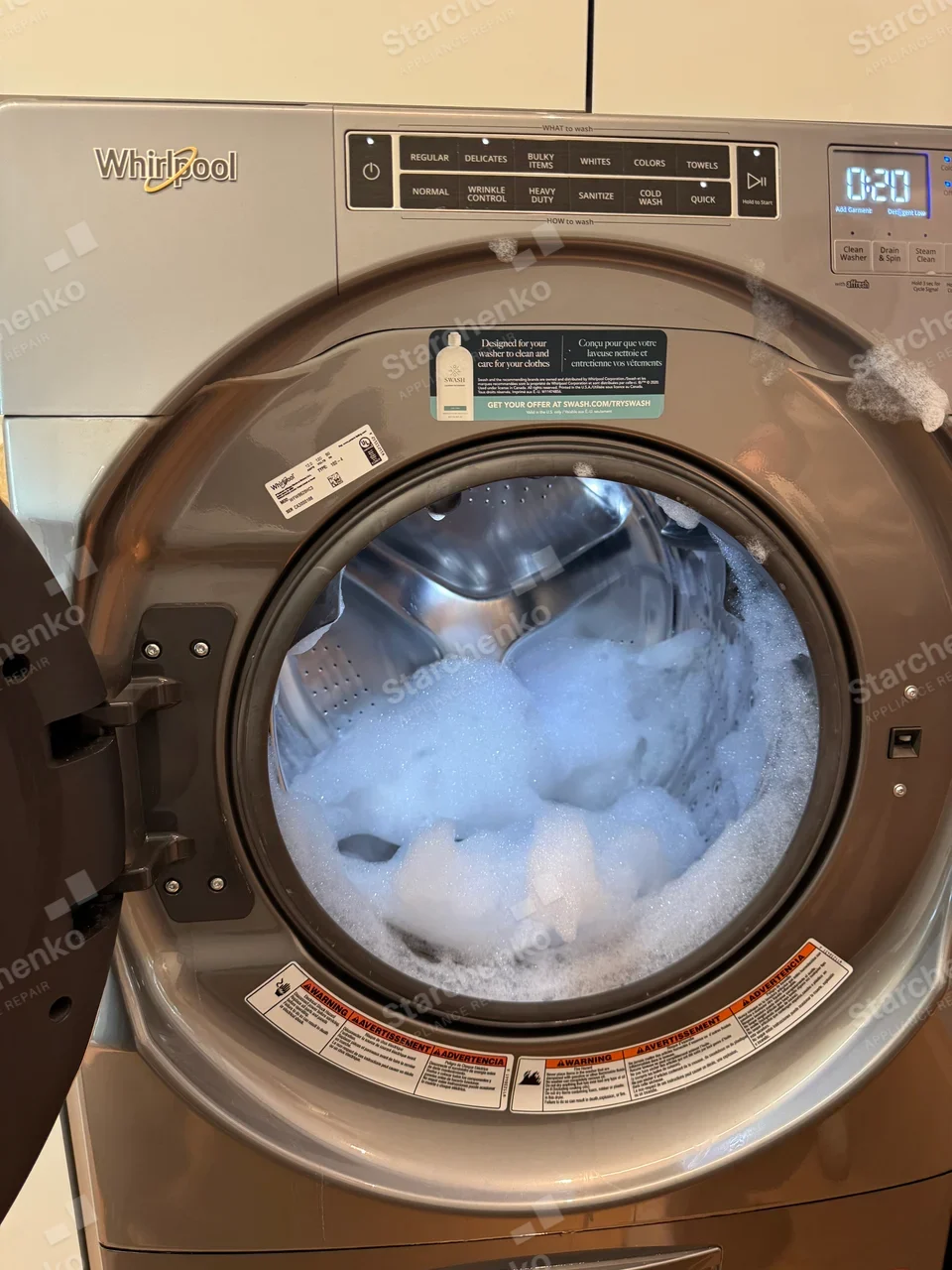 Whirlpool front-load washer with the door open and the drum full of detergent suds